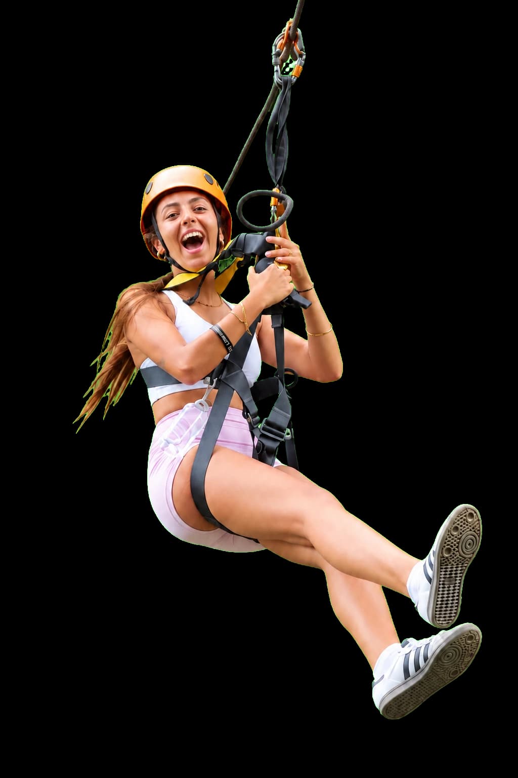 A Flying Hanuman guest in an orange helmet soaring on a zipline